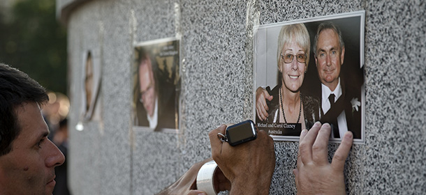 Ukrainians tape pictures of victims of the MH17 air crash on a wall before a memorial concert in Kharkiv, Ukraine, Thursday, July 24, 2014. Two military aircraft carrying remains of victims from the Malaysian plane disaster departed for the Netherlands on July 24, while Australian and Dutch diplomats joined to promote a plan for a U.N. team to secure the crash scene which has been controlled by pro-Russian rebels. (AP Photo/Vadim Ghirda)