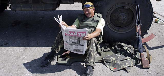 A Ukrainian soldier reads a newspaper at a checkpoint in the eastern city of Debaltseve on August 6, 2014. Russian President Vladimir Putin slapped a one-year ban and restriction on food and agricultural product imports from nations that have imposed sanctions on Russia over its defiant stance on Ukraine. AFP PHOTO/ ANATOLII STEPANOV (Photo credit should read ANATOLII STEPANOV/AFP/Getty Images)