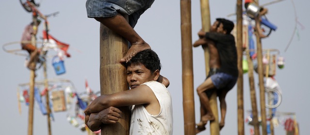 I prigionieri si arrampicano sui pali scivolosi per cercare di raggiungere i premi che sono appesi in cima.
(AP Photo/Dita Alangkara)