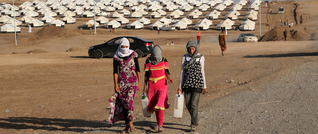 Displaced Iraqis from the Yazidi community settle at a new camp outside the old camp of Bajid Kandala at Feeshkhabour town near the Syria-Iraq border, Iraq, Friday, Aug. 15, 2014. The U.N. this week declared the situation in Iraq a "Level 3 Emergency" — a decision that came after some 45,000 members of the Yazidi religious minority were able to escape from a remote desert mountaintop where they had been encircled by Islamic State fighters. The extremist group views them as apostates and had vowed to kill any who did not convert to Islam. (AP Photo/Khalid Mohammed)