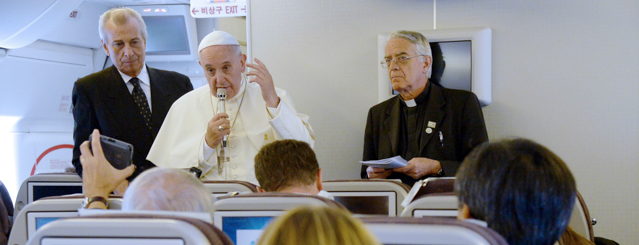 Pope Francis (C) and Father Federico Lombardi (R) give a press conference aboard the plane carrying him back to Rome at the end of a five-day trip to South-Korea, on August 18, 2014. AFP PHOTO / VINCENZO PINTO (Photo credit should read VINCENZO PINTO/AFP/Getty Images)