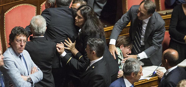 Il senatore Gianmarco Centinaio (Lega Nord) blocca i commessi del Senato, mentre la senatrice Laura Bianconi (NCD) viene ferita alla spalla. (Roberto Monaldo / LaPresse)