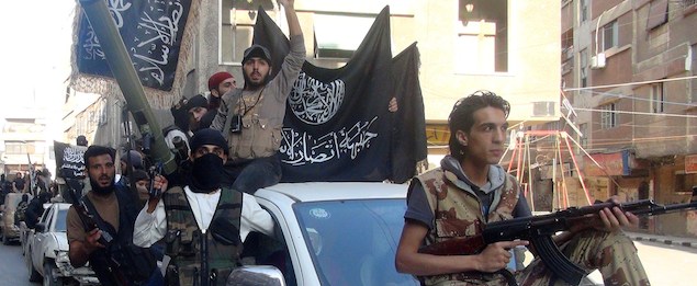 Islamic fighters from the al-Qaida group in the Levant, Al-Nusra Front, wave their movement's flag as they parade at the Yarmuk Palestinian refugee camp, south of Damascus, to denounce Israels military offensive on the Gaza Strip, on July 28, 2014. Israeli shells struck a UN school in Gaza early today, killing 16, as ground troops made a signficant push into the territory despite Palestinian efforts to broker a 24-hour truce. AFP PHOTO/RAMI AL-SAYED (Photo credit should read RAMI AL-SAYED/AFP/Getty Images)