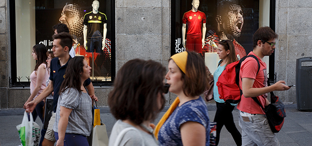 MADRID, SPAIN - JUNE 10: People walk past a window display with replica Spain football team in front of boards with the picture of Xavi Hernandez (L) and Diego Costa (R) on June 10, 2014 in Madrid, Spain. Current champion Spain team will play their first match of the FIFA World cup against Netherlands in Salvador de Bahia, Brazil on June 13, 2014. (Photo by Pablo Blazquez Dominguez/Getty Images)