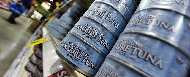 Canned tuna are pictured as a man shops at Wegmans Foods store in Fairfax, Virginia, on February 24, 2011. Wegmans, the supermarket chain, which has locations in Lanham, Fairfax, Sterling and Woodbridge, said it will freeze the prices on 40 products for the rest of the year. The products include orange juice, coffee, cereal, bananas, red peppers, pasta and sauce. Also on the list are chicken, ground beef, salmon, tilapia, tuna, frozen pizza, frozen vegetables and deli ham and turkey. AFP PHOTO/Jewel Samad (Photo credit should read JEWEL SAMAD/AFP/Getty Images)