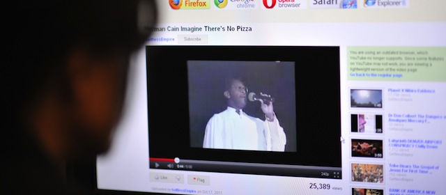 An office worker watches a video made in 1991 and posted on YouTube, featuring the US Republican Party Presidential hopefull Herman Cain performing a version of John Lennon's song "Imagine" with changed lyrics, on October 18, 2011 in Washington, DC. Cain was CEO of the Omaha-based restaurant chain Godfather's Pizza at the time of his recording release. The latest opinion polls give long-time front-runner Mitt Romney 26 percent for the Republican presidential nomination, with Cain only one point behind at 25 percent, well ahead of the next-placed Texas governor Rick Perry. AFP PHOTO/Mladen ANTONOV (Photo credit should read MLADEN ANTONOV/AFP/Getty Images)