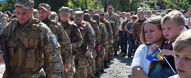 People watch Sich special volonteer battalion members leave on August 26, 2014 after an oath-taking and farewell ceremony in Kiev. The battalion is leaving the Ukrainian capital to take part in anti-terrorists operation (ATO) in the east of the country. Kiev's security services on August 26 released a video purporting to show captured 10 Russian soldiers captured on its territory who a Moscow military source claimed had crossed into Ukraine "by accident." AFP PHOTO / SERGEI SUPINSKY (Photo credit should read SERGEI SUPINSKY/AFP/Getty Images)