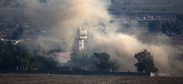 In a picture taken from the Israeli-annexed Golan Heights, smoke billows from the Syrian village of Quneitra following an explosion during fighting, between forces loyal to Syrian President Bashar Assad and rebels, near the Quneitra border crossing on August 31, 2014. Heavy fighting between Syrian government troops and opposition forces overflowed into the buffer zone separating Syrian and Israeli-occupied territory over the weekend. AFP PHOTO/ MENAHEM KAHANA (Photo credit should read MENAHEM KAHANA/AFP/Getty Images)