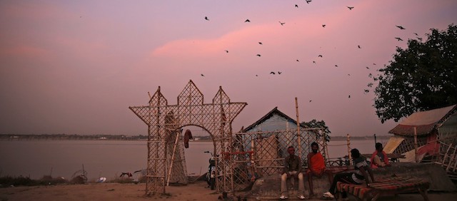 Birds fly at dusk as Hindu devotees rest on the banks of the Sangam, the confluence of rivers Ganges, Yamuna, and mythical Saraswati in Allahabad, India, Saturday, Aug. 23, 2014. The confluence is considered one of Hinduism’s holiest sites. (AP Photo/ Rajesh Kumar Singh)