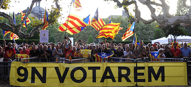 People wave “estelada” flags, that symbolize Catalonia's independence, during a demonstration calling for the independence of Catalonia outside of the Parliament of Barcelona, Spain, Friday, Sept. 19, 2014. A day after Scotland rejected breaking away from Britain, the regional parliament in Spain's Catalonia is expected to grant its leader the power to call a secession referendum that the central government in Madrid says would be illegal. Banner reads, 'On 9 Nov, we will vote.' (AP Photo/Manu Fernandez)
