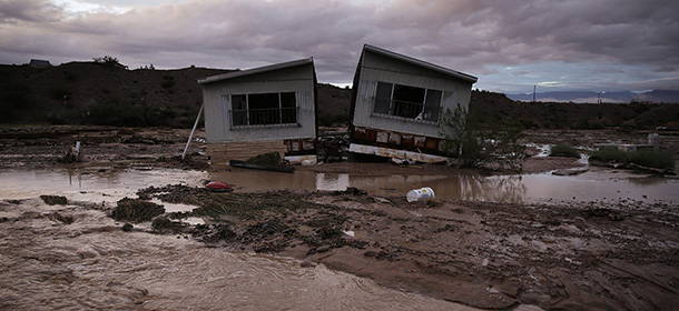 Receding flood water surrounds a home in Moapa, Nev., Monday, Sept. 8, 2014. Flooding throughout the area damaged homes and roads. (AP Photo/John Locher)