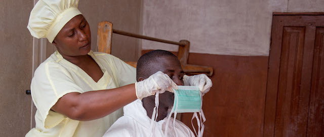 In this photo taken on Tuesday, Aug. 12, 2014, a healthcare worker, left, helps a collegue as she prepares his Ebola personal protective equipment before entering the Ebola isolation ward at Kenema Government Hospital, in Kenema, the Eastern Province around 300km, (186 miles), from the capital city of Freetown in Sierra Leone. Over the decades, Ebola cases have been confirmed in 10 African countries, including Congo where the disease was first reported in 1976. But until this year, Ebola had never come to West Africa. (AP Photo/ Michael Duff)