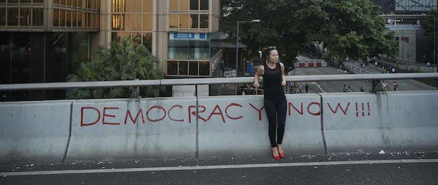 A woman rests on an overpass closed due to a massive protest in Hong Kong, Monday, Sept. 29, 2014. Pro-democracy protesters expanded their rallies throughout Hong Kong on Monday, defying calls to disperse in a major pushback against Beijing's decision to limit democratic reforms in the Asian financial hub. (AP Photo/Wally Santana)