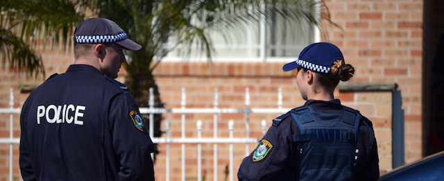 Police officers stand guard outside a house during a raid in the Guildford area of Sydney on September 18, 2014. Australia's largest ever counter-terrorism raids detained 15 people and disrupted plans to "commit violent acts", including against random members of the public that reportedly involved a beheading on camera. AFP PHOTO / Saeed Khan (Photo credit should read SAEED KHAN/AFP/Getty Images)