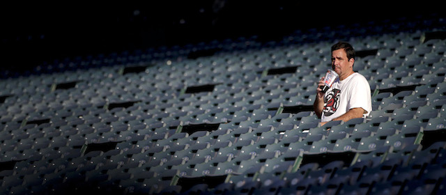 A lone fan drinks his soda while watching the Los Angeles Angels practice before a baseball game against the Seattle Mariners Monday, Sept. 15, 2014, in Anaheim, Calif. Southern California is roasting in triple-digit temperatures and forecasters say the heat wave will continue at least another day. (AP Photo/Jae C. Hong)