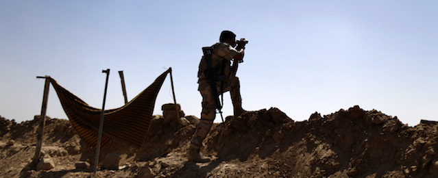 A Kurdish Peshmerga fighter uses binoculars to check on Islamic State group's positions on the outskirts of Makhmour, 300 kilometers (186 miles) north of Baghdad, Iraq, Saturday, Sept. 6, 2014. The U.S. and nine key allies agreed Friday that the Islamic State group is a significant threat to NATO countries and that they will take on the militants by squeezing their financial resources and going after them with military might. (AP Photo/ Marko Drobnjakovic)
