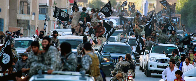 FILE - In this undated image posted on Monday, June 30, 2014, by the Raqqa Media Center of the Islamic State group, a Syrian opposition group, which has been verified and is consistent with other AP reporting, fighters from the Islamic State group parade in Raqqa, north Syria. The U.S. and its allies are trying to hammer out a coalition to push back the Islamic State group in Iraq. But any serious attempt to destroy the militants or even seriously degrade their capabilities means targeting their infrastructure in Syria. That, however, is far more complicated. If it launches airstrikes against the group in Syria, the U.S. runs the risk of unintentionally strengthening the hand of President Bashar Assad, whose removal the West has actively sought the past three years. Uprooting the Islamic State, which has seized swaths of territory in both Syria and Iraq, would potentially open the way for the Syrian army to fill the vacuum. (AP Photo/Raqqa Media Center of the Islamic State group, File)