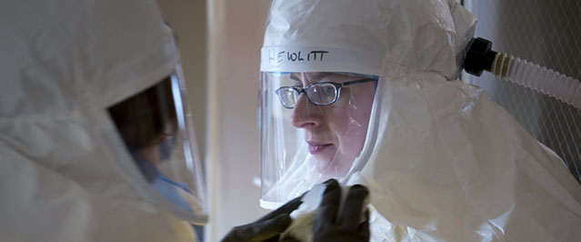 Angela Hewlett, assistant medical director of the Nebraska Biocontainment Patient Care Unit at the Nebraska Medical Center in Omaha, Neb., gets assistance putting on protective gear during a drill in February at the biocontainment unit, where an Ebola patient is being treated. Illustrates EBOLA-DOCTOR (category a), by Angela Hewlett, Special to The Washington Post. Moved Sunday, Oct. 12, 2014. (MUST CREDIT: Taylor Wilson/Nebraska Medical Center)