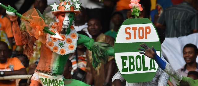 A disguised supporter of Ivory Coast's national football team holds a placard reading "Stop Ebola", as he attends the 2015 African Cup of Nations qualifying football match between Ivory Coast and Sierra Leone on September 6, 2014 at the Felix Houphouet-Boigny stadium in Abidjan. AFP PHOTO / ISSOUF SANOGO (Photo credit should read ISSOUF SANOGO/AFP/Getty Images)