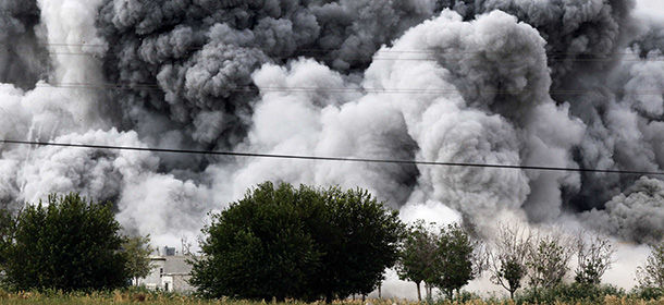 SANLIURFA, TURKEY - OCTOBER 12: Heavy smoke rises from the Syrian town of Kobani, seen from near the Mursitpinar border crossing on the Turkish-Syrian border in the southeastern town of Suruc in Sanliurfa province on October 12, 2014 in Sanliurfa, Turkey. Kurdish forces defending Kobani urged a U.S.-led coalition to escalate air strikes on Islamic State fighters who tightened their grip on the Syrian town at the border with Turkey. A group that monitors the Syrian civil war said the Kurdish forces faced inevitable defeat in Kobani if Turkey did not open its border to let through arms, something Ankara has appeared reluctant to do. (Photo by Gokhan Sahin/Getty Images)
