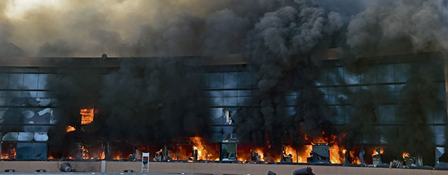 View of the Municipal Palace in Chilpancingo, Guerrero state after students set it on fire on October 13, 2014 during a protest to demand the finding of the 43 peers missing since an attack by rogue officers earlier this month. Authorities are investigating whether the students were buried in mass graves found outside Iguala, a city 200 kilometers (125 miles) south of Mexico City. AFP PHOTO/ Yuri CORTEZ (Photo credit should read YURI CORTEZ/AFP/Getty Images)