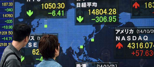 A couple looks at the electronic stock quotation board at the window of a security company in central Tokyo on October 21, 2014. Tokyo stocks dropped 306.95 points or 2.03 percent to close at 14,804.28 on October 21 as investors locked in profits after the previous day's rise of almost four percent, while the yen rose against the dollar and weak China growth data hit sentiment. AFP PHOTO / TOSHIFUMI KITAMURA (Photo credit should read TOSHIFUMI KITAMURA/AFP/Getty Images)