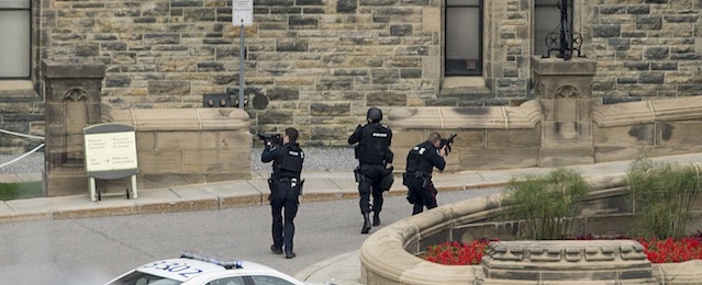 Police teams enter Centre Block at Parliament Hill in Ottawa on Wednesday Oct. 22, 2014. A soldier standing guard at the National War Memorial was shot by an unknown gunman and people reported hearing gunfire inside the halls of Parliament. Prime Minister Stephen Harper was rushed away from Parliament Hill to an undisclosed location, according to officials. (AP Photo/The Canadian Press, Justin Tang)
