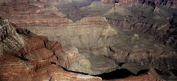 FILE - This Oct. 5, 2013 file photo, the Grand Canyon National Park is covered in the morning sunlight as seen from a helicopter near Tusayan, Ariz. An effort by the Grand Canyon to make a lucrative contract more attractive to bidders means the park will defer planned spending on new lighting, cave monitoring, building a composting toilet and tracking an endangered fish that recently reappeared in the canyon, it was announced Wednesday, Sept. 24, 2014.(AP Photo/Julie Jacobson, File)