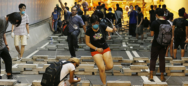 Demonstrators block the underpass with concrete slabs taken from drainage ditches at the main roads outside government headquarters in Hong Kong's Admiralty, Wednesday, Oct. 15, 2014. Pro-democracy activists clashed with police and barricaded a tunnel near Hong Kong's government headquarters late Tuesday, expanding their protest zone again after being cleared out of some other streets in the latest escalation of tensions in a weeks long political crisis. (AP Photo/Kin Cheung)