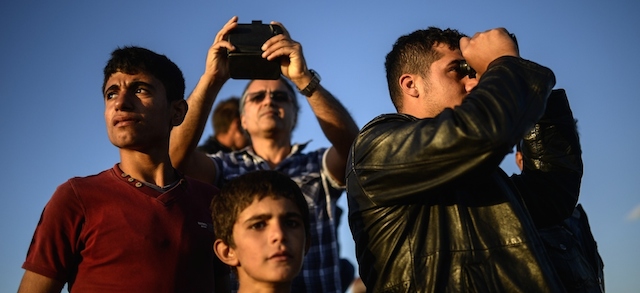 Curdi siriani rifugiati nella provincia turca di Sanlinurfa guardano gli scontri tra peshmerga e combattenti dell'IS in Siria, non lontano dal confine. 
(BULENT KILIC/AFP/Getty Images)