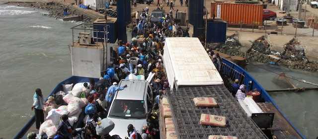 Passengers stream aboard a ferry as workers prepare for it to leave harbor at Banjul, Gambia, on Saturday Dec. 31, 2011. The ferry connects the capital of Banjul to the city of Barra in the tiny country. (AP Photo/Jon Gambrell).