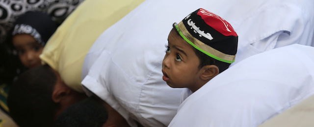 An Egyptian boy offers Eid al-Adha prayers with his family outside a mosque in Cairo, Egypt, Saturday, Oct. 4, 2014. Muslims around the world celebrated Eid al-Adha Saturday to commemorate the willingness of the prophet Ibrahim - or Abraham as he is known in the Bible - to sacrifice his son in accordance with God's will, though in the end God provides him a sheep to sacrifice instead. The major Muslim holiday coincides this year with the Jewish holiday of Yom Kippur, the first time this has happened since 1981. (AP Photo/Hassan Ammar)