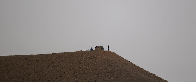 Two Egyptian soldiers in their military position stand guard along the Egypt-Israel border seen from the Red Sea resort city of Eilat, southern Israel, Sunday, March 9, 2014. A senior security official in Egypt said a missile shipment seized by Israel last week was destined for militants in either the Sinai Peninsula or the Gaza Strip. (AP Photo/Ariel Schalit)