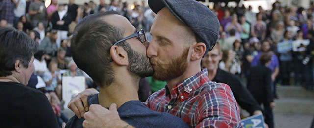 Plaintiffs, Moudi Sbeity, left, and his partner Derek Kitchen kiss during a gay marriage rally Monday, Oct. 6, 2014, in Salt Lake City. Same-sex couples in Utah were celebrating after the U.S. Supreme Court on Monday cleared the way for gay marriages to begin in this state and 30 others. The high court on Monday rejected an appeal from Utah and four other states that had sought to bar weddings between gay couples. (AP Photo/Rick Bowmer)