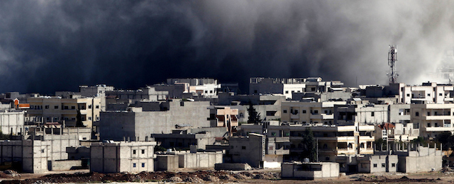 SANLIURFA, TURKEY - OCTOBER 22: (TURKEY OUT) Heavy smoke and dust rise over Syrian town of Kobani after an airstrike, as seen from the Mursitpinar crossing on the Turkish-Syrian border in the southeastern town of Suruc in Sanliurfa province October 22, 2014. The Syrian town of Kobani was yet again hit by fierce fighting between Islamic State and Syrian Kurdish forces. Turkey has agreed to allow Iraqi Kurdish fighters to travel through its territory in order to provide reinforcements for the Syrian Kurdish force. The U.S. has conducted airstrikes on Islamic State positions within the town and dropped supplies and weapons for its defenders. (Photo by Gokhan Sahin/Getty Images)