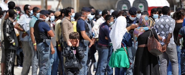 Immigrants, part of a group of more than 1,700 people, wait after they disembarked from the Italian military ship "San Giusto" on August 11, 2014 in the port of Reggio Calabria, southern Italy, following Mare Nostrum rescue operations at sea. The Italian navy said on August 11 it had rescued more than 2,000 migrants over the weekend from boats in the Mediterranean, bringing the number it has brought ashore this year to nearly 100,000. They are picked up as part of Italy's "Mare Nostrum" operation, a large-scale naval deployment that was launched after twin shipwrecks in October left more than 400 migrants dead. AFP PHOTO/GIOVANNI ISOLINO (Photo credit should read GIOVANNI ISOLINO/AFP/Getty Images)