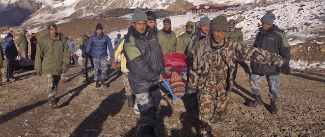 In this photo provided by the Nepalese army, soldiers carry an avalanche victim before he is airlifted in Thorong La pass area, Nepal, Wednesday, Oct. 15, 2014. An avalanche and blizzard in Nepal's mountainous north have killed at least 12 people, including eight foreign trekkers, officials said Wednesday. Five other climbers were hit by a separate avalanche on Mount Dhaulagiri and remain missing. (AP Photo/Nepalese Army)
