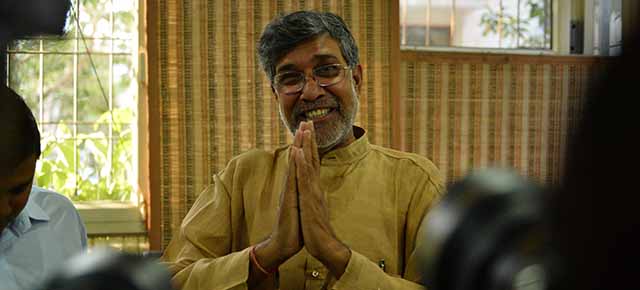 Indian activist Kailash Satyarthi gestures for photographers at this home office after the announcement of him receiving the Nobel Peace Prize, in New Delhi on October 10, 2014. Indian activist Kailash Satyarthi said October 10 his Nobel Peace Prize would help highlight the plight of children around the world, and invited fellow winner Malala Yousafzai to work with him. AFP PHOTO / CHANDAN KHANNA (Photo credit should read Chandan Khanna/AFP/Getty Images)