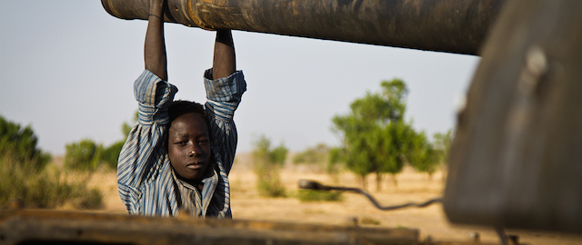 Photo taken on April 3, 2012 shows a Sudanese youngster hanging off the barrel of an abandoned Sudan Armed Forces, SAF, tank at Dar in South Kordofan, Sudan.Amid heavy artillery bombardments and airstrikes, Sudan described the South's seizure of the contested oil-producing Heglig region from its army as the worst violation of its territory, pulling out of African Union-led talks in protest and edging the closest to all-out war on April 11, 2012. AFP photo/Adrianne OHANESIAN (Photo credit should read ADRIANE OHANESIAN/AFP/Getty Images)