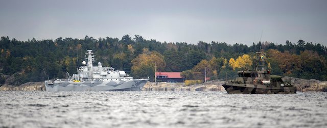 The Swedish minesweeper HMS Kullen, left, and a guard boat in Namdo Bay, Sweden,Tuesday, Oct. 21, 2014 on their fifth day of searching for a suspected foreign vessel in the Stockholm archipelago. The navy has demanded a 1000-meter (yard) no-go radius around naval vessels taking part in the current operation. (AP Photo/TT News Agency, Fredrik Sandberg) SWEDEN OUT