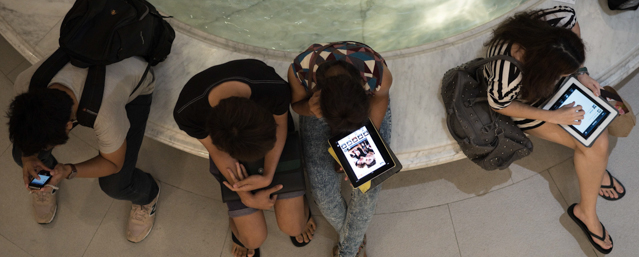 This picture taken on March 19, 2013 shows people using their smartphones and tablets in a shopping mall in Bangkok. A recent Facebook-sponsored study showed smartphone owners are often connected all day. People can be found glued to their smartphones at airports, on trains, in restaurants and even while walking on the street, creating a disconnection from their immediate surroundings. Smartphone sales are expected to continue to surge in 2013 with some 918 million units to be bought worldwide. AFP PHOTO/ Nicolas ASFOURI (Photo credit should read NICOLAS ASFOURI/AFP/Getty Images)