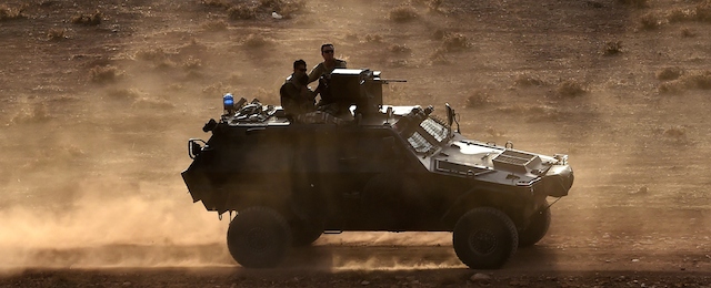 A Turkish armoured vehicle patrols at the Turkish-Syrian border area opposite the Syrian town of Ain al-Arab, known as Kobane by the Kurds, in the southeastern village of Mursitpinar, in Sanliurfa province, on October 13, 2014. Kurdish fighters engaged in fierce clashes with jihadists on the Turkish border near Kobane, as Washington pressed Ankara to play a stronger role in the campaign against the Islamic State group. AFP PHOTO / ARIS MESSINIS (Photo credit should read ARIS MESSINIS/AFP/Getty Images)
