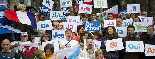 European citizens hold leaflets with the word 'Yes' written in different languages during a photocall with Scottish First Minister Alex Salmond and European citizens to celebrate European citizenship and Scotland's continued EU membership with a Yes vote, during a photocall in Edinburgh, Scotland, on September 9, 2014, ahead of the referendum on Scotland's independence. British Prime Minister David Cameron and opposition leader Ed Miliband said in a joint statement they would travel to Scotland on Wednesday as polls show those for and against independence evenly split ahead of next week's referendum. AFP PHOTO / LESLEY MARTIN (Photo credit should read LESLEY MARTIN/AFP/Getty Images)