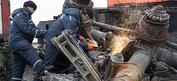 Dutch experts supervise a crew from the emergency ministry of the self-proclaimed Donetsk People's Republic as they break up and load parts of the Malaysia Airlines Flight MH17 onto the back of a lorry at the crash site near the village of Grabove, in eastern Ukraine, on November 16, 2014. Workers began removing the wreckage of Malaysia Airlines flight MH17 from rebel-held territory in eastern Ukraine, four months after it was shot down killing 298 passengers and crew. AFP PHOTO / MENAHEM KAHANA (Photo credit should read MENAHEM KAHANA/AFP/Getty Images)