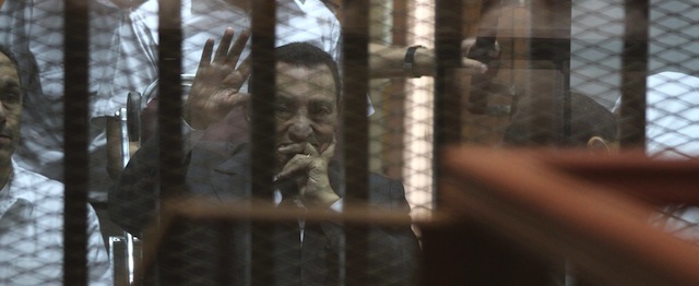 QUALITY REPEAT 
Egypt's deposed president Hosni Mubarak waves from behind the accused cage during his trial on May 21, 2014 in Cairo. An Egyptian court sentenced Mubarak to three years in prison on corruption charges, in one of two trials after the 2011 uprising that ended his rule. AFP PHOTO / HASSAN MOHAMED (Photo credit should read HASSAN MOHAMED/AFP/Getty Images)