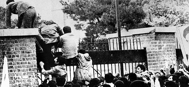 (FILES) Iranian students climb over the wall of the US embassy in Tehran 04 November 1979. Twenty years later, 04 November 1999, the former embassy building now turns out officers of the Islamic Republic's Revolutionary Guards.