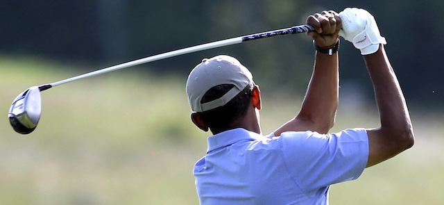 President Barack Obama follows through on a practice swing before teeing off while golfing at Vineyard Golf Club, Tuesday, Aug. 12, 2014, in Edgartown, Mass., on the island of Martha's Vineyard. President Obama is taking a two-week summer vacation on the island. (AP Photo/Steven Senne)