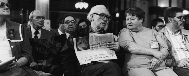 English Labour politician and writer, Michael Foot, sitting in the conference hall and holding a copy of the Independent newspaper during the Labour Party Conference, circa 1990. The pensioner's leader and former leader of the Transport Workers Union, Jack Jones, is sitting behind him (second from left). (Photo by Steve Eason/Hulton Archive/Getty Images)