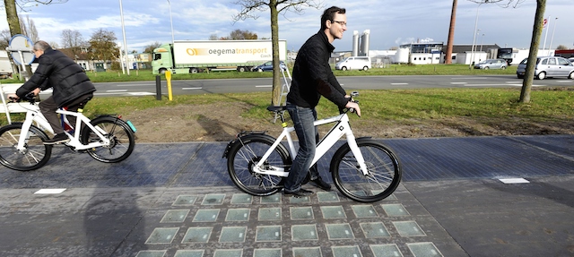 Cyclists use the SolaRoad, the first road in the world made of solar panels, during the official opening in Krommenie on November 12, 2014. The Netherlands unveiled the world's first solar bike path, a revolutionary project to harvest the sun's energy that could eventually also be used on roads. The so-called "SolaRoad" bike path is made of concrete modules each measuring 2.5 by 3.5 metres (eight by 11 feet), embedded with solar panels covered in tempered glass. AFP PHOTO/ANP/EVERT ELZINGA
== NETHERLANDS OUT == (Photo credit should read EVERT ELZINGA/AFP/Getty Images)