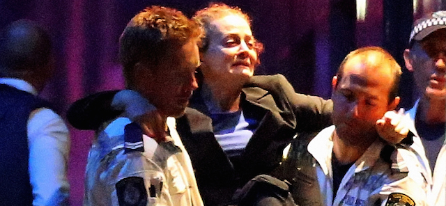 SYDNEY, AUSTRALIA - DECEMBER 15: (EDITORS NOTE: Retransmission with alternate crop.) A woman is carried out by police from the Lindt Cafe, Martin Place following a hostage standoff on December 15, 2014 in Sydney, Australia. Police stormed the Sydney cafe as a gunman had been holding hostages for 16 hours. (Photo by Joosep Martinson/Getty Images)